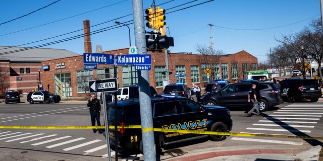 Swarms of police respond to Grifols Biomat USA Plasma Center on reports of shots fired in downtown Kalamazoo, Michigan on Tuesday, March 12, 2019. Authorities say a police officer has been shot while responding to the shooting. (Joel Bissell/Kalamazoo Gazette via AP)