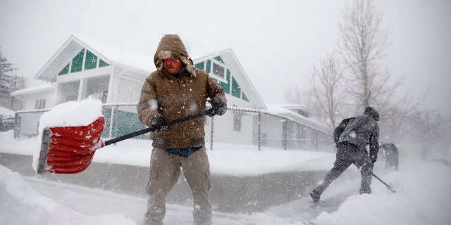 Martin Thompson clears snow from the sidewalk Wednesday, March 13, 2019 during a winter storm in Casper, Wyo. The storm brought blizzard conditions to parts of Colorado, Wyoming, Montana, Nebraska and South Dakota. (Josh Galemore/The Casper Star-Tribune via AP)
