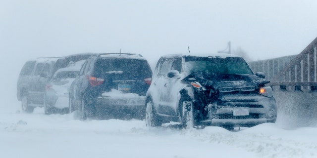 A string of wrecked vehicles sit on an overpass over Interstate 70 as a late winter storm packing hurricane-force winds and snow sweeps over the intermountain West Wednesday, March 13, 2019, in Aurora, Colo. (AP Photo/David Zalubowski)