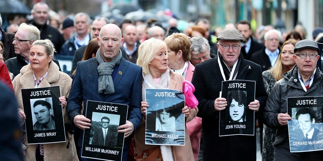 Families hold photographs of the victims of Bloody Sunday and march through the Bogside in Londonderry, Northern Ireland, Thursday, March 14, 2019.