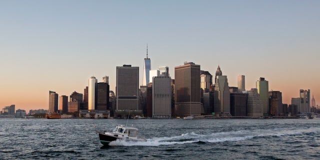 FILE - In this Oct. 19, 2017 file photo, a boat crosses New York Harbor in front of the Manhattan skyline. Mayor Bill de Blasio is announcing a plan, Thursday, March 14, 2019, to protect lower Manhattan from rising sea levels by surrounding it with earthen berms and extending its shoreline by as much as 500 feet. (AP Photo/Mark Lennihan, File)