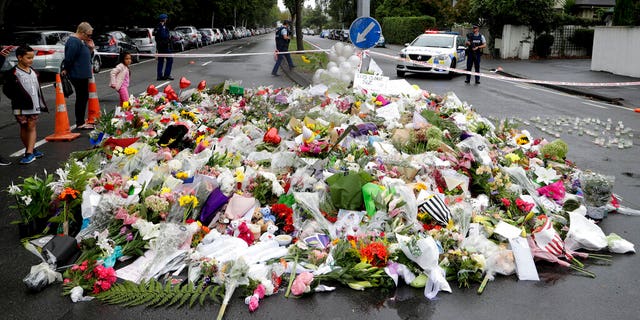 Mourners place flowers as they pay their respects at a makeshift memorial near the Masjid Al Noor mosque in Christchurch, New Zealand, Sunday, March 17, 2019, where one of the two mass shootings occurred.