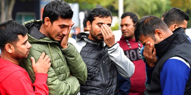 Friends of a missing man grieve outside a refuge center in Christchurch.