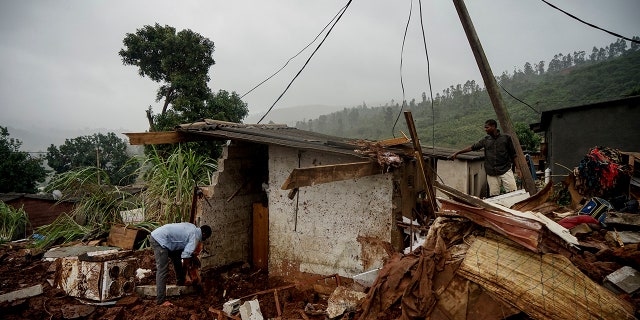 Men search to salvage what they can from a house which was damaged by Cyclone Idai in Chimanimani, Zimbabwe, Saturday, March 23, 2019 after Cyclone Idai caused floods that swept through Mozambique, Zimbabwe and Malawi. A second week has begun of efforts to find and help some tens of thousands of people in devastated parts of southern Africa, with some hundreds dead and an unknown number of people still missing.(AP Photo/KB Mpofu)