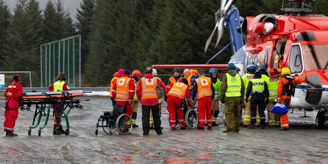 Passengers are helped from a rescue helicopter in Fraena, Norway, Sunday.