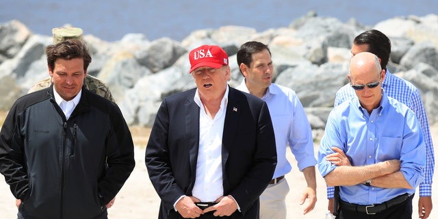 President Donald Trump walks with, from left, Florida Gov. Ron DeSantis, Sen. Marco Rubio, R-Fla., and Sen. Rick Scott, R-Fla., during a visit to Lake Okeechobee and Herbert Hoover Dike at Canal Point, Fla., Friday, March 29, 2019. (AP Photo/Manuel Balce Ceneta)