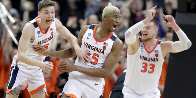 Virginia's Mamadi Diakite, center, reacts with teammates Kyle Guy and Jack Salt (33) after hitting a shot to send the game into overtime in the men's NCAA Tournament college basketball South Regional final game against Purdue, Saturday, March 30, 2019, in Louisville, Ky. (Associated Press)