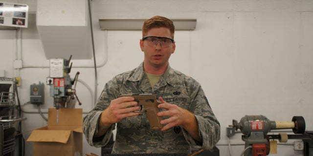 Tech. Sgt. Brady Craddock, non-commissioned officer in charge of the Air Force Gunsmith Shop, explains the benefits of the M18 modular handgun system. (U.S. Air Force photo by Vicki Stein/Released)