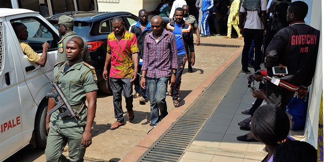 Men arrested in connection with Cameroon's anglophone crisis are seen at the military court in Yaounde, Cameroon, on December 14, 2018. - Nearly 300 people who were arrested in connection with Cameroon's anglophone crisis will be released on Friday, a day after being pardoned by President Paul Biya, the defense minister said.