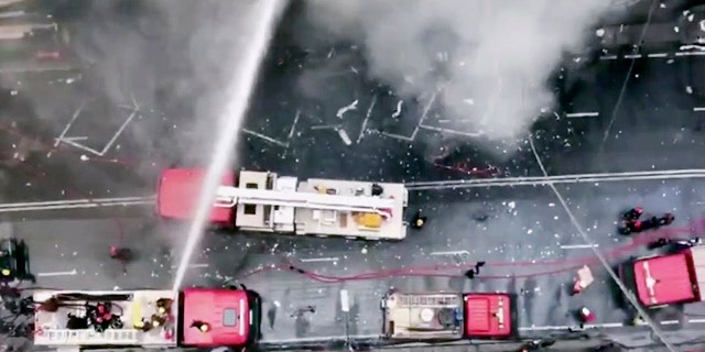 In this image made from video, firetrucks hose down a building on fire in the Banani area of Dhaka, Bangladesh, Thursday, March 28, 2019. An official in the Fire Department control room says the fire had broken out in an office building in Bangladesh's capital, and some people are feared trapped inside. (AP Photo)