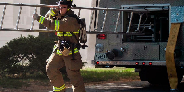 Berwick Fire Capt. Joel Barnes pulling a ladder on the scene of a June 2017 structure fire in Somersworth N.H. (Erin Thomas via AP, File)