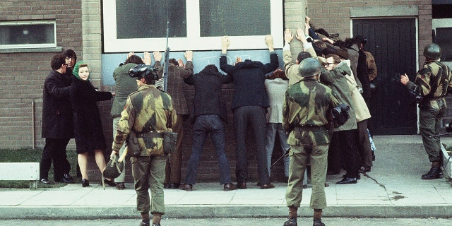 British troops arrest civilians on Rossville St, Londonderry, during a civil rights march. The day went on to become known as Bloody Sunday as British paratroopers shot dead 14 civilians.