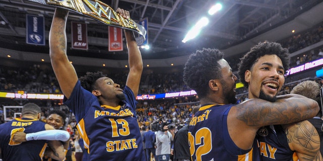 Murray State's Brion Whitley (22) hugs Tevin Brown (10) as Devin Gilmore (13) celebrates behind them the team's win over Belmont in an NCAA college basketball game for the championship of the Ohio Valley Conference men's tournament Saturday, March 9, 2019, in Evansville, Ind. (AP Photo/Daniel R. Patmore)