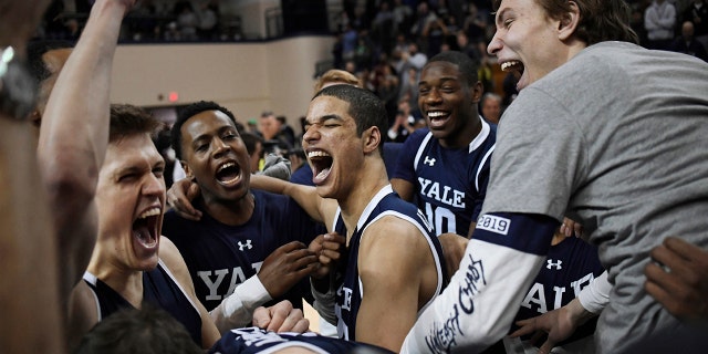 Yale basketball players celebrate their Ivy League championship win over Harvard after an NCAA college basketball game at Yale University in New Haven, Conn., Sunday, March 17, 2019, in New Haven, Conn. (AP Photo/Jessica Hill)