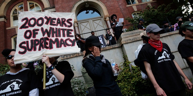Protesters with the group Students Act Against White Supremacy speak on the campus of the University of Virginia during an event marking the one year anniversary of a deadly clash between white supremacists and counter-protesters Aug. 11, 2018, in Charlottesville, Va.