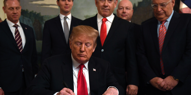 President Donald Trump, front, signs a proclamation in the Diplomatic Reception Room at the White House in Washington, Monday, March 25, 2019. Trump signed an official proclamation formally recognizing Israel's sovereignty over the Golan Heights. Others attending are, from left, Acting Defense Secretary Patrick Shanahan, White House adviser Jared Kushner, Israeli Prime Minister Benjamin Netanyahu, U.S. special envoy Jason Greenblatt, and U.S. Ambassador to Israel David Friedman. (AP Photo/Susan Walsh)