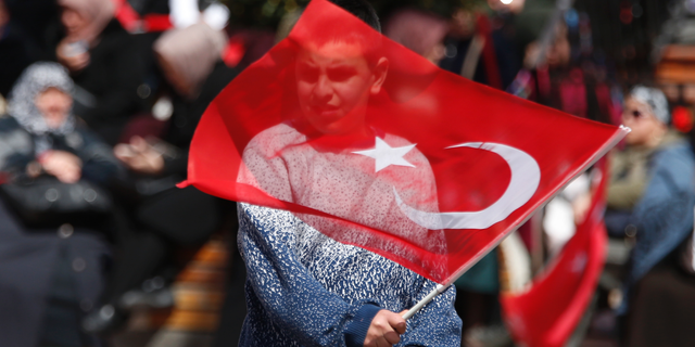 A supporter of Turkey's President Recep Tayyip Erdogan waves a flag at a rally of his ruling Justice and Development Party's (AKP), in Istanbul, Friday, March 29, 2019, ahead of local elections scheduled for March 31, 2019. (AP Photo/Lefteris Pitarakis)