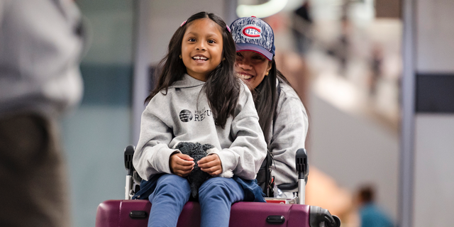 Vanessa Rodel and her 7-year-old daughter Keana exit Lester B. Pearson Airport in Toronto on Monday, March 25, 2019. The Filipino woman who helped shelter former NSA contractor Edward Snowden when he fled to Hong Kong has been granted refugee status in Canada. (Christopher Katsarov/The Canadian Press via AP)