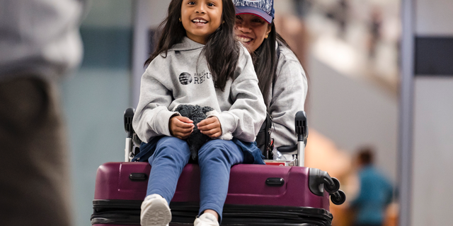 Vanessa Rodel and her 7-year-old daughter Keana exit Lester B. Pearson Airport in Toronto on Monday, March 25, 2019. The Filipino woman who helped shelter former NSA contractor Edward Snowden when he fled to Hong Kong has been granted refugee status in Canada. (Christopher Katsarov/The Canadian Press via AP)