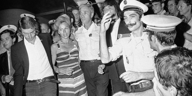 FILE - In this July 5, 1976 file photo, head pilot Michel Bacos, center left, is reunited with his wife, 2nd left, and son at Orly Airport near Paris, France, as the 12-member crew of the hijacked Air France Airbus jetliner and 14 passengers return home from Tel Aviv after a week-long stay at Entebbe Airport in Uganda. The French pilot of the Air France plane hijacked to Uganda's Entebbe airport in 1976, in which 110 hostages were freed by Israeli commandos, has died at the age of 95. (AP Photo, File)