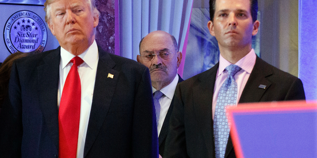 FILE - In this Jan. 11, 2017, file photo, Allen Weisselberg, center, stands between President-elect Donald Trump, left, and Donald Trump Jr., at a news conference in the lobby of Trump Tower in New York.
