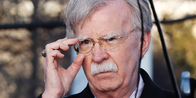 FILE - In this March 5, 2019, file photo, U.S. National Security Adviser John Bolton adjusts his glasses before an interview at the White House in Washington. Bolton is condemning Venezuela President Nicolas Maduro, saying he is using foreign military personnel to stay in power. Bolton further warned external actors _ those outside the Western Hemisphere _ against deploying military assets to Venezuela or anywhere else in the hemisphere. He says the U.S. will view such actions as "provocative" and a "direct threat to international peace and security in the region."  (AP Photo/Jacquelyn Martin, File)