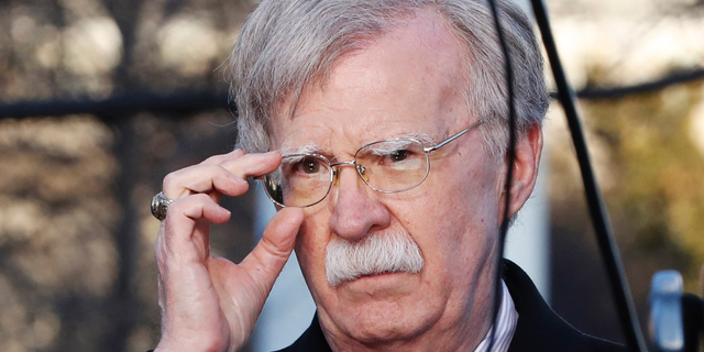 FILE - In this March 5, 2019, file photo, U.S. National Security Adviser John Bolton adjusts his glasses before an interview at the White House in Washington. Bolton is condemning Venezuela President Nicolas Maduro, saying he is using foreign military personnel to stay in power. Bolton further warned external actors _ those outside the Western Hemisphere _ against deploying military assets to Venezuela or anywhere else in the hemisphere. He says the U.S. will view such actions as "provocative" and a "direct threat to international peace and security in the region." (AP Photo/Jacquelyn Martin, File)