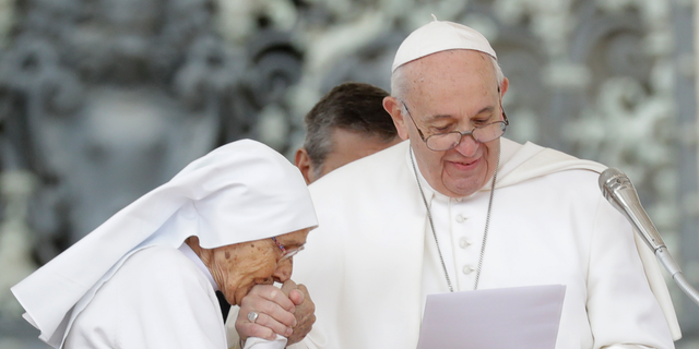 Sister Maria Concetta Esu kisses the hand of Pope Francis as he presents her with a Pro Ecclesia et Pontifice award during his weekly general audience, in St. Peter's Square, at the Vatican, Wednesday, March 27, 2019. (AP Photo/Andrew Medichini)