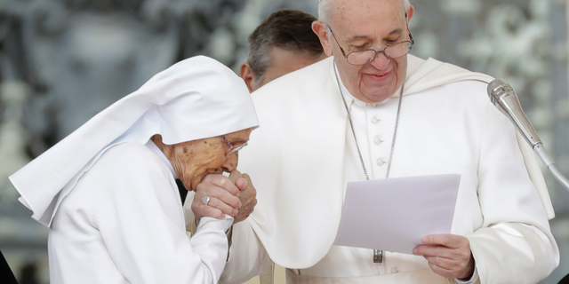 Sister Maria Concetta Esu kisses the hand of Pope Francis as he presents her with a Pro Ecclesia et Pontifice award during his weekly general audience, in St. Peter's Square, at the Vatican, Wednesday, March 27, 2019. (AP Photo/Andrew Medichini)