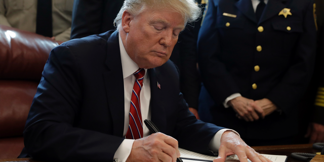 President Donald Trump signs the first veto of his presidency in the Oval Office of the White House, Friday, March 15, 2019, in Washington. Trump issued the first veto, overruling Congress to protect his emergency declaration for border wall funding. (AP Photo/Evan Vucci)
