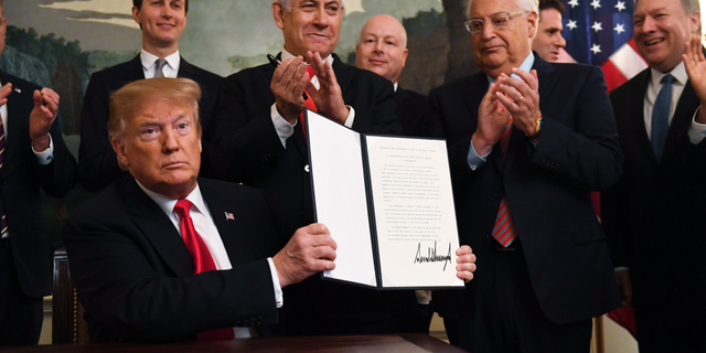 President Donald Trump holds up a signed proclamation recognizing Israel's sovereignty over the Golan Heights, as Israeli Prime Minister Benjamin Netanyahu looks on in the Diplomatic Reception Room of the White House in Washington, Monday, March 25, 2019. (AP Photo/Susan Walsh)