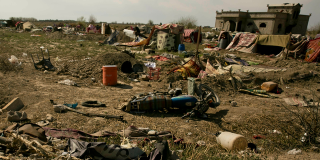 An Islamic State militant flag, foreground ,lies in a tent encampment after U.S.-backed Syrian Democratic Forces (SDF) fighters took control of Baghouz, Syriaon Saturday, March 23, 2019. The elimination of the last Islamic State stronghold in Baghouz brings to a close a grueling final battle that stretched across several weeks and saw thousands of people flee the territory and surrender in desperation, and hundreds killed. (AP Photo/Maya Alleruzzo)