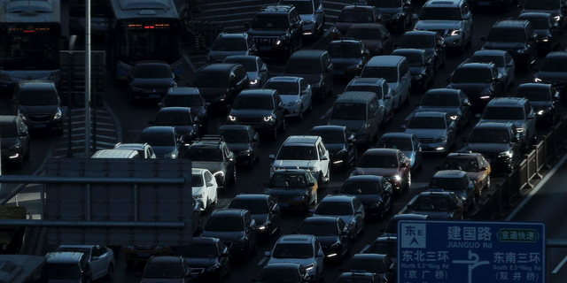 A beam of sunlight is cast on vehicles on a city ring-road clogged with heavy traffic during the morning rush hour in Beijing, Dec. 11, 2018. (Associated Press)