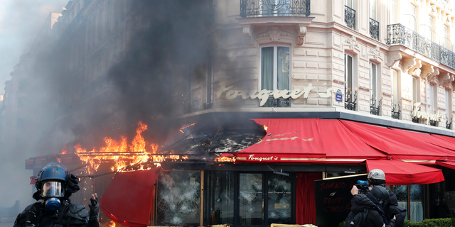 Paris famed restaurant Fouquet's burns on the Champs Elysees avenue during a yellow vests demonstration Saturday, March 16, 2019 in Paris. Paris police say more than 100 people have been arrested amid rioting in the French capital by yellow vest protesters and clashes with police. They set life-threatening fires, smashed up luxury stores and clashed with police firing tear gas and water cannon