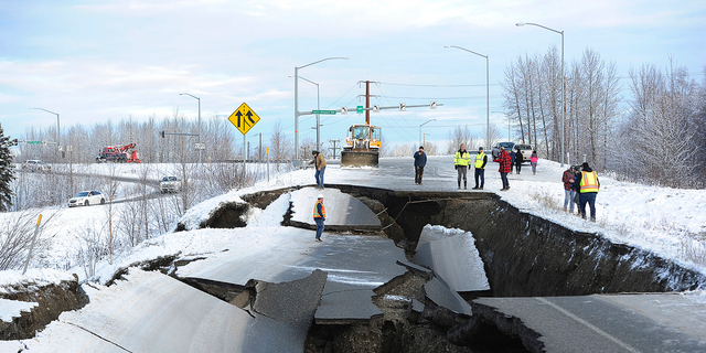 FILE - In this Nov. 30, 2018, file photo, workers inspect an off-ramp that collapsed during a morning earthquake in Anchorage, Alaska. Seismologists announced Friday, March 8, 2019, the magnitude of Alaska's powerful Nov. 30 earthquake has been revised to 7.1 from the earlier magnitude 7.0. Alaska Earthquake Center officials say in a release that the change comes after quake data was reviewed by multiple agency and academic groups. (AP Photo/Mike Dinneen, File)