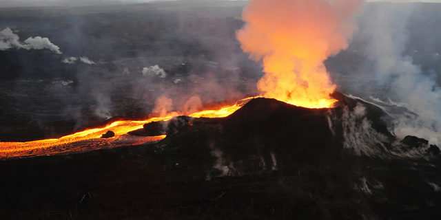 FILE - In this July 14, 2018 photo provided by the U.S. Geological Survey, lava from Kilauea volcano erupts in the Leilani Estates neighborhood near Pahoa, Hawaii. Scientists have downgraded the alert level for Hawaii's Kilauea volcano in response to reduced activity, saying the next eruption is likely a few years away. The U.S. Geological Survey's Hawaiian Volcano Observatory announced Tuesday, March 26, 2019, that the alert level for the Big Island volcano has been lowered from "advisory" to "normal," the Hawaii Tribune-Herald reported. (U.S. Geological Survey via AP, File)