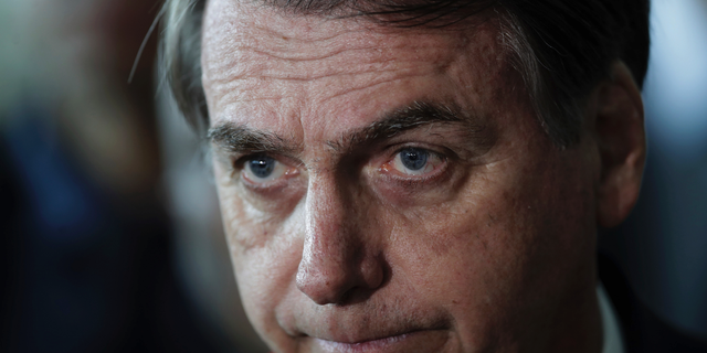Brazil's President Jair Bolsonaro listens to a reporter's question at the end of a military ceremony where he was awarded the Order of Military Judicial Merit, in Brasilia, Brazil, Thursday, March 28, 2019. Bolsonaro, a former army captain who waxes nostalgic for the 1964-1985 dictatorship, on Monday asked Brazil’s Defense Ministry to organize “due commemorations” to mark the upcoming March 31st anniversary of Brazil’s 1964 military coup. (AP Photo/Eraldo Peres)