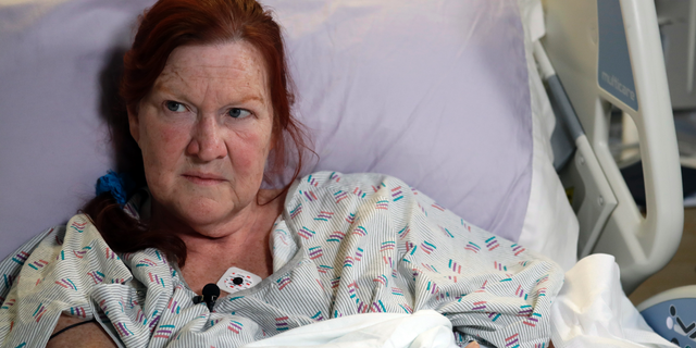 Deborah Judd, 56, sits in her hospital bed at Harborview Medical Center and talks about the injuries she suffered in a shooting a day earlier, Thursday, March 28, 2019, in Seattle. The afternoon shooting spree and carjacking in Seattle left two people dead and two injured. (AP Photo/Elaine Thompson)