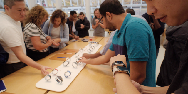 FILE- In this Sept. 21, 2018 file photo customers look at Apple Watches at an Apple store in New York. (AP Photo/Patrick Sison, File)
