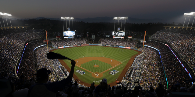 FILE - In this Oct. 27, 2018, file photo, fans cheer from the top of Dodger Stadium during Game 4 of the World Series baseball game between the Boston Red Sox and Los Angeles Dodgers in Los Angeles. Los Angeles police say a 47-year-old man was hospitalized after an argument turned violent outside Dodger Stadium. Police say the man was punched once by another man and fell to the ground in a parking lot following the six-hour game Friday night against the Arizona Diamondbacks. (AP Photo/Elise Amendola, File)