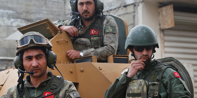 FILE - In this March 24, 2018 file photo, Turkish soldiers atop an armored personnel carrier secure the streets of the northwestern city of Afrin, Syria, during a Turkish government-organized media tour into northern Syria. Turkish military said Sunday, March. 31, 2019 that one of its soldier has been killed in Syria’s north in what Syrian activists describe as an attack by local Kurdish fighters. Turkey's ministry of defense said a mortar attack Sunday on its troops around Afrin in northwestern Syria killed one soldier and wounded another. (AP Photo/Lefteris Pitarakis, File)