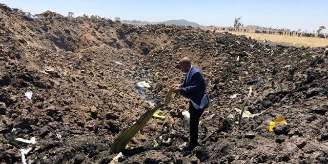In this photo taken from the Ethiopian Airlines Facebook page, the CEO of Ethiopian Airlines, Tewolde Gebremariam, looks at the wreckage of the plane that crashed shortly after takeoff from Addis Ababa, Ethiopia, Sunday March 10, 2019.