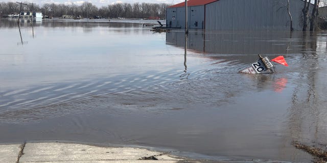 A road sign and building sitting in water left behind after the Missouri River rose to record heights, flooding a huge swath of land in the city Plattsmouth, Nebraska. (Fox News)