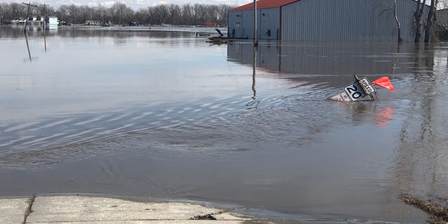 A road sign and a building sitting in the water left behind after the Missouri River reached record heights, flooding a huge strip of land in the city of Plattsmouth, Nebraska. (Fox News)