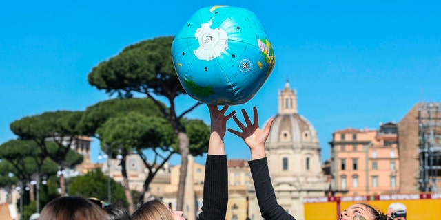 Studenti a Roma giocano con un mappamondo gonfiabile mentre marciano per chiedere azioni sul cambiamento climatico, 15 marzo 2019.