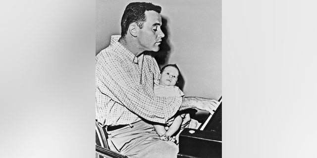 Little Christopher Lemmon is wide-eyed at the playing of his father, actor Jack Lemmon. Lemmon was taking time out from the filming of the movie "Phffft" to hold two-and-a-half-month-old Chris for his camera debut. — Getty