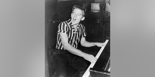 Portrait of rock 'n' roll recording artist Jerry Lee Lewis. He is shown seated at the piano, singing.
