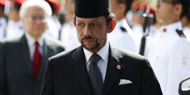 Sultan of Brunei Hassanal Bolkiah walks back after inspecting the guard of honor, accompanied by Singapore President, Tony Tan Keng Yam during the welcome ceremony at the Istana on July 5, 2017 in Singapore.