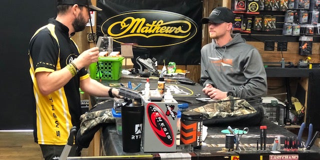 Robb Herring (left) talks with a colleague as he repairs an arrow at the archery store he manages. (Fox News/Charles Watson)
