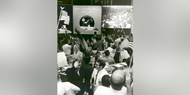 Flight controllers at Mission Control applaud the splashdown and success of the Apollo 11 lunar mission on July 24, 1969. (NASA)